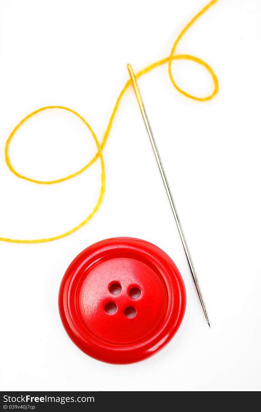 Button with needle and thread isolated on white background