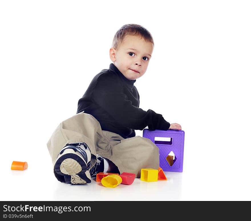 An adorable preschooler playing with a colorful 3-D puzzle. Isolated on white. An adorable preschooler playing with a colorful 3-D puzzle. Isolated on white.