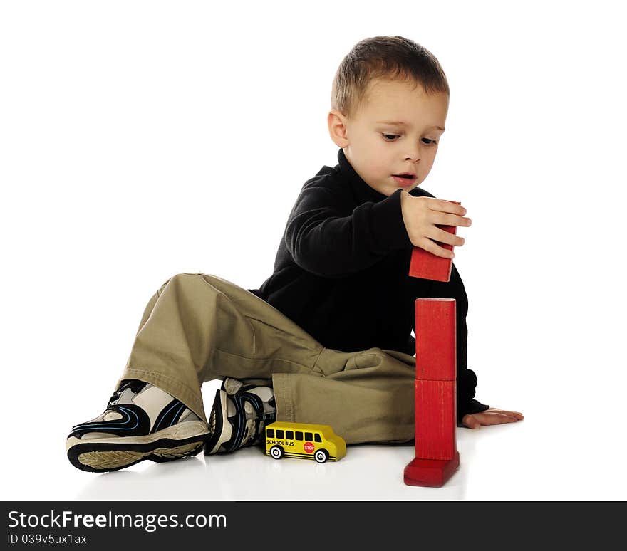 An adorable preschooler stacking red blocks end to end. Isolated on white. An adorable preschooler stacking red blocks end to end. Isolated on white.