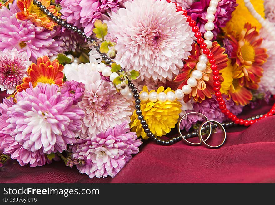 Colorful chrysanthemum, daisy flowers and wedding rings. Colorful chrysanthemum, daisy flowers and wedding rings