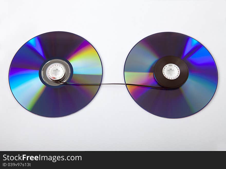 Two discs with a cassette tape between them. Two discs with a cassette tape between them