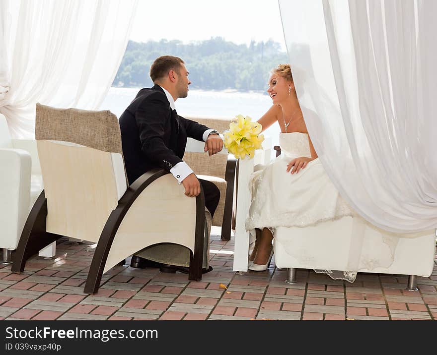 Bride and groom drinking coffee at an outdoor cafe