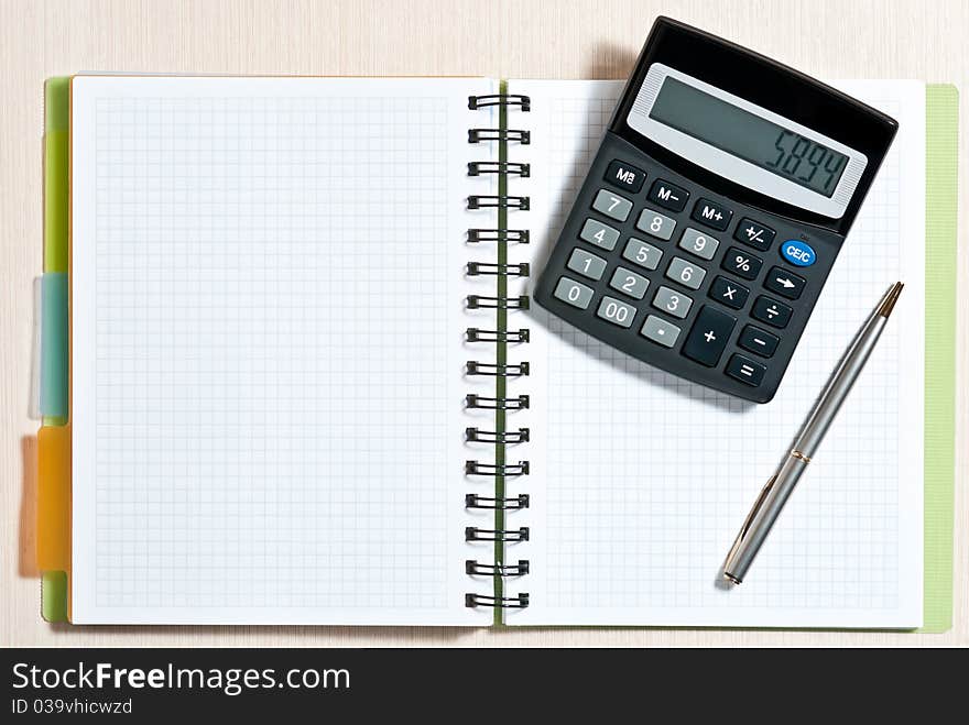 Notebook, ballpen and calculator on wooden desk. Notebook, ballpen and calculator on wooden desk