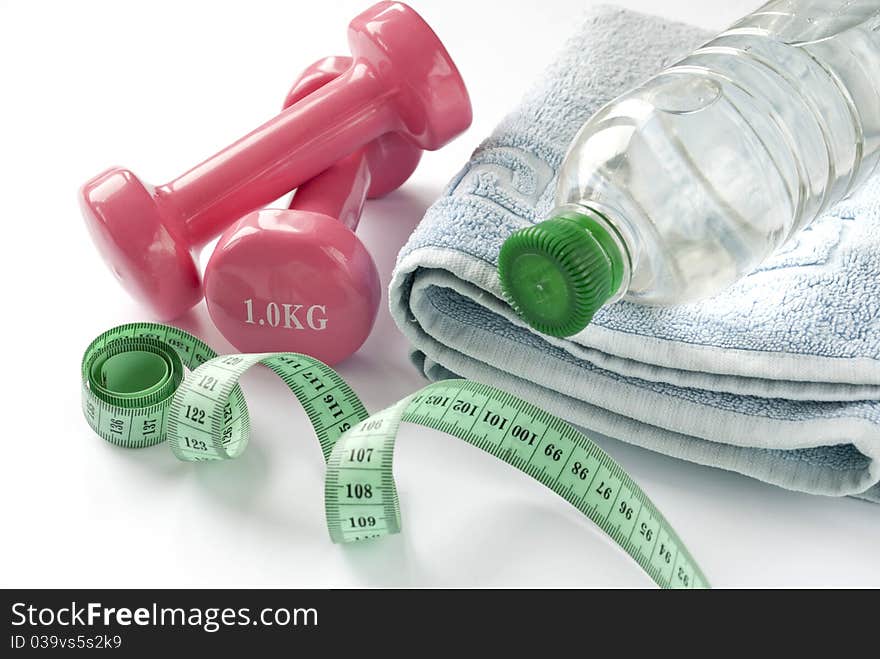 A pair of dumbbells, a towel and water.