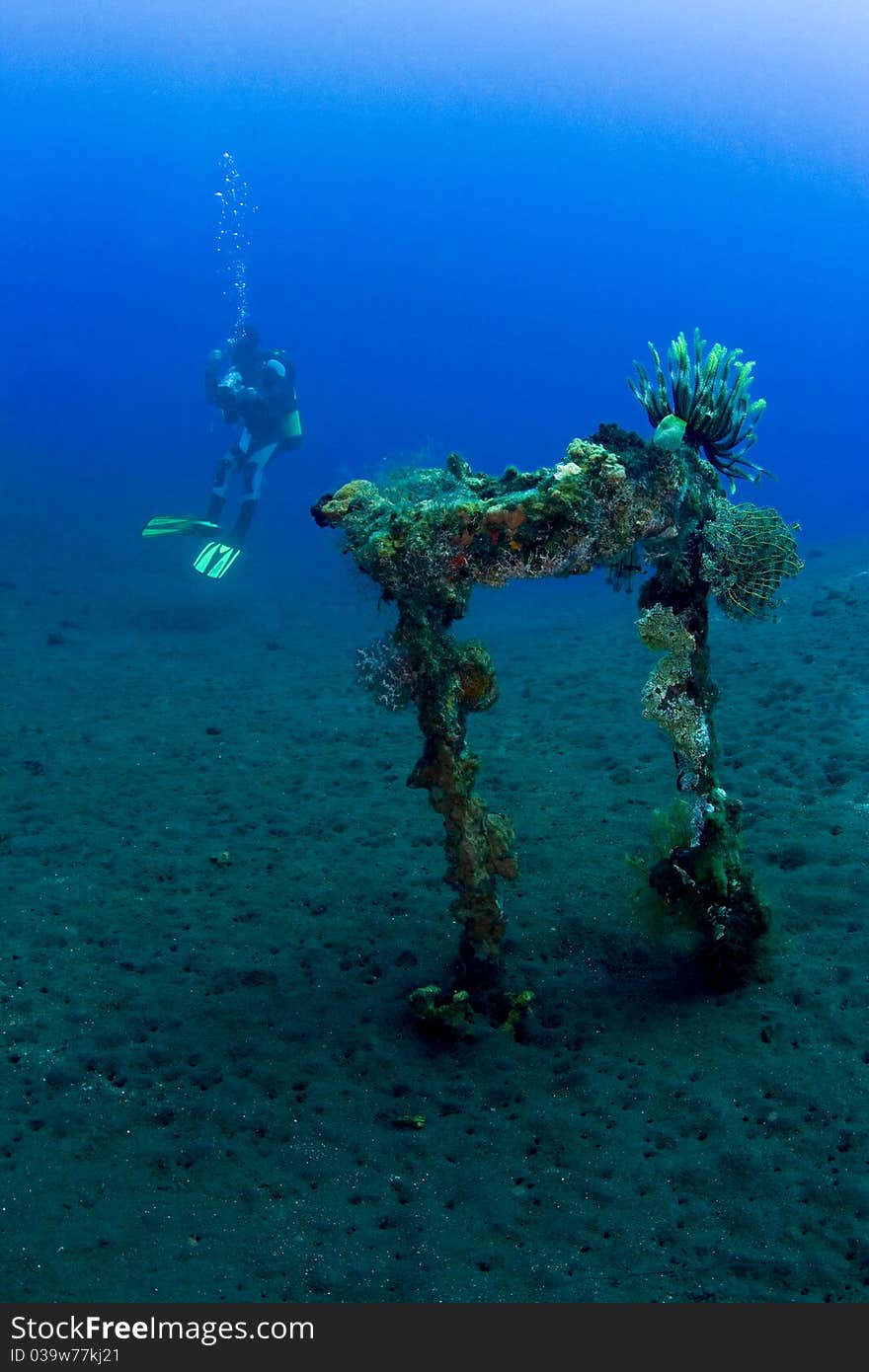 Diver with part of the liberty wreck over volcanic black sand. Taken at Tulumben, Bali, Indonesia. Diver with part of the liberty wreck over volcanic black sand. Taken at Tulumben, Bali, Indonesia.