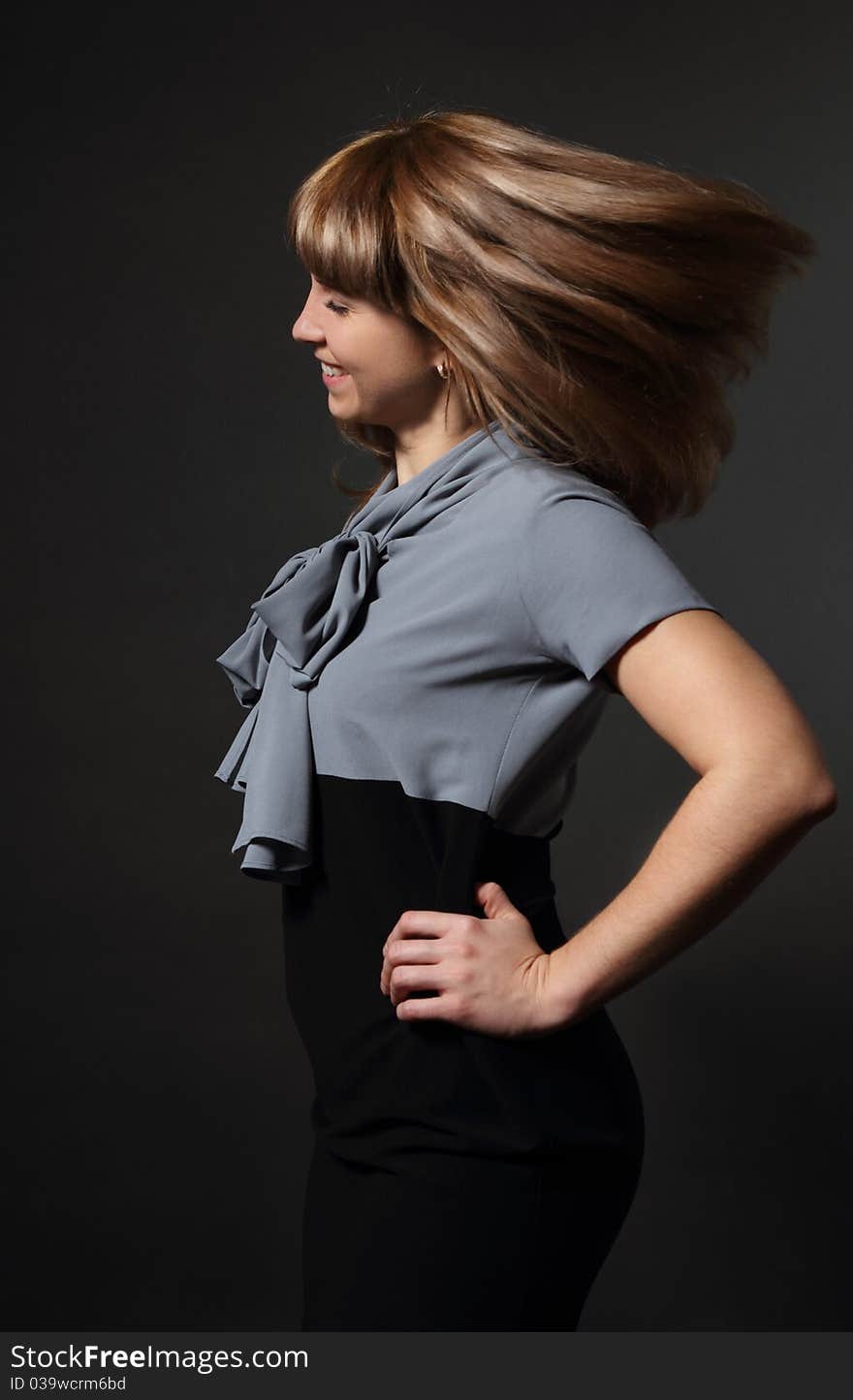 Portrait of young beauty woman with fluttering hair over dark background