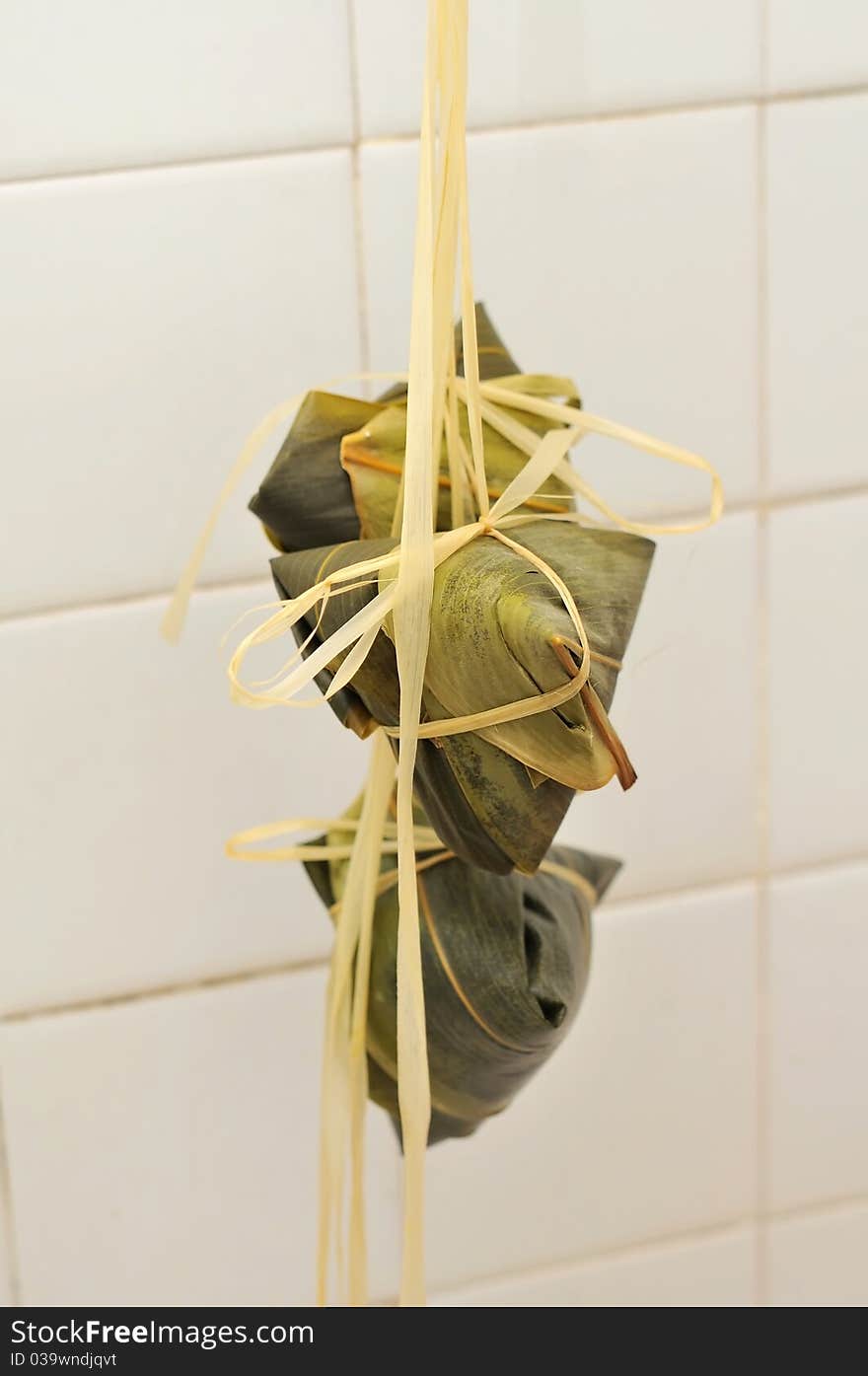 A bunch of Chinese meat dumplings wrapped in bamboo leaf.