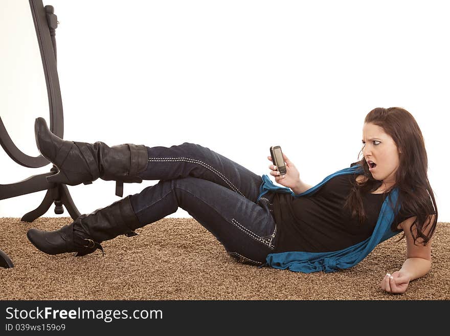 A woman is looking at her phone with a mad expression. A woman is looking at her phone with a mad expression.