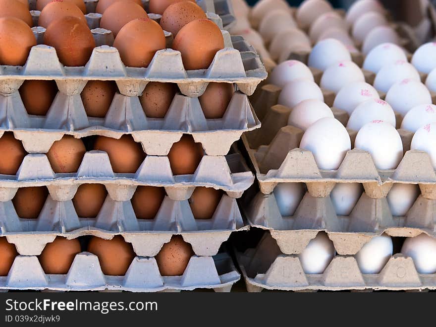 Many brown and white eggs stacked in staircase. Many brown and white eggs stacked in staircase