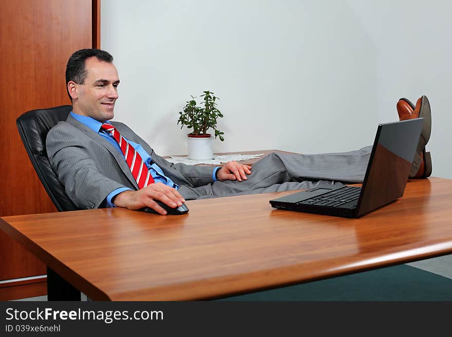 Successful businessman looking at computer how his earnings grow.