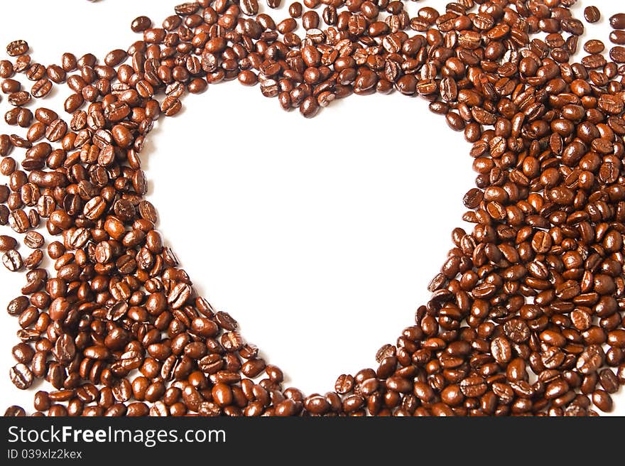 Heart from brown coffee beans on white background