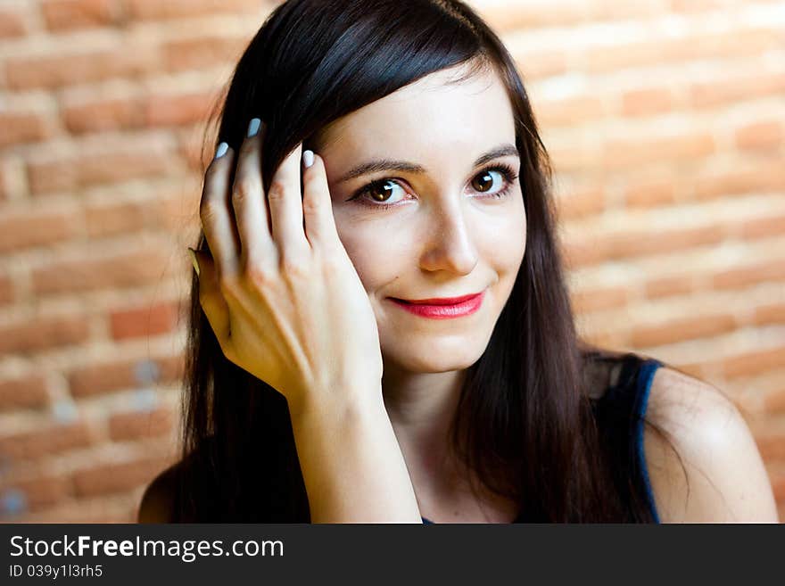 Portrait of a close-up beautiful girl on a background of brick wall. Portrait of a close-up beautiful girl on a background of brick wall