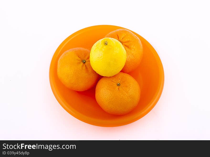 Fruit on an orange plate on a white background