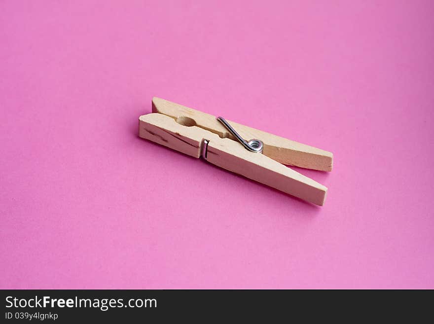 Wooden peg against a pink background