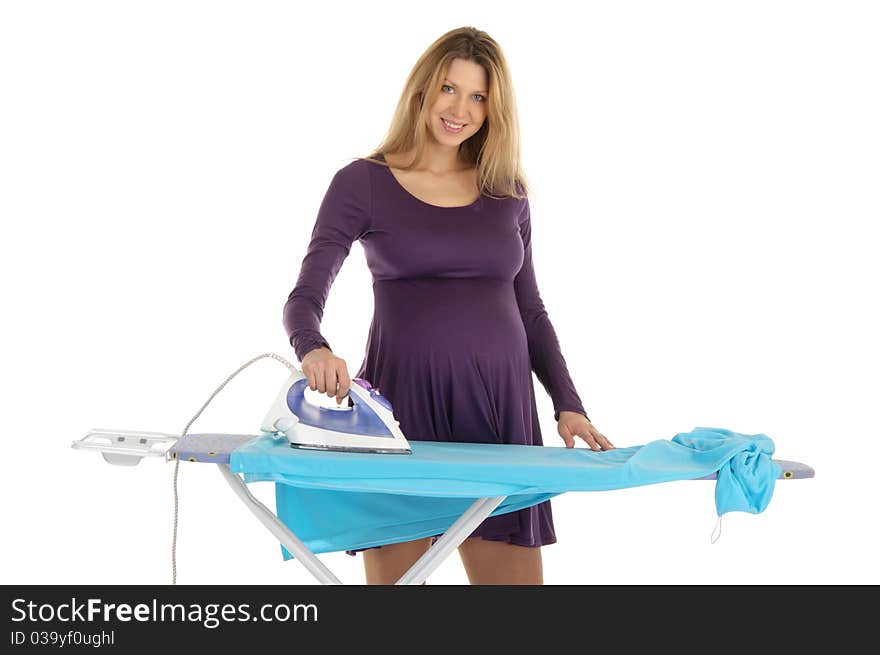 Pregnant woman in a purple dress with an iron isolated on white