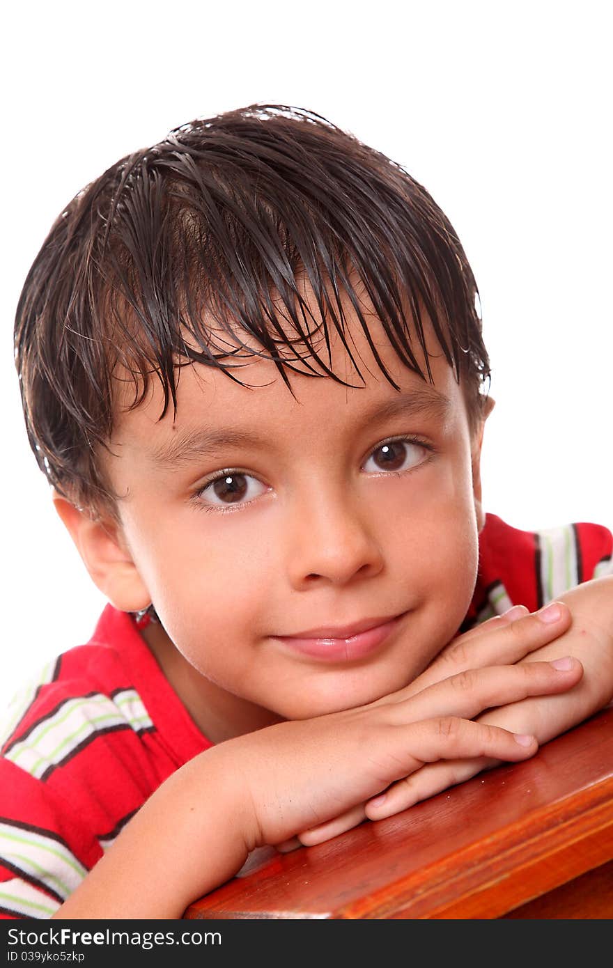 6 year old boy leaning on his hands over white background. 6 year old boy leaning on his hands over white background