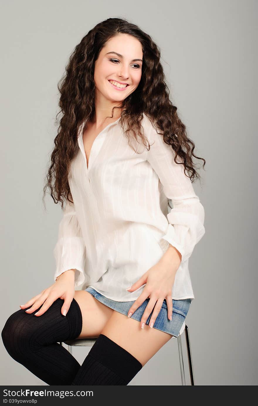 Smiling beautiful young brunet woman in white shirt studio shoot. Smiling beautiful young brunet woman in white shirt studio shoot