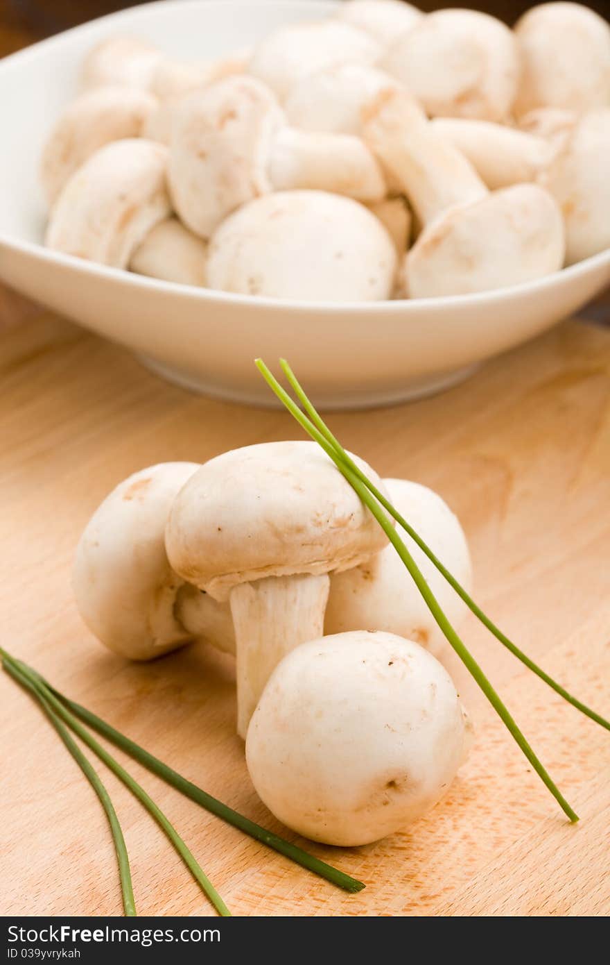 Photo of delicious raw mushroomw on chopping board. Photo of delicious raw mushroomw on chopping board