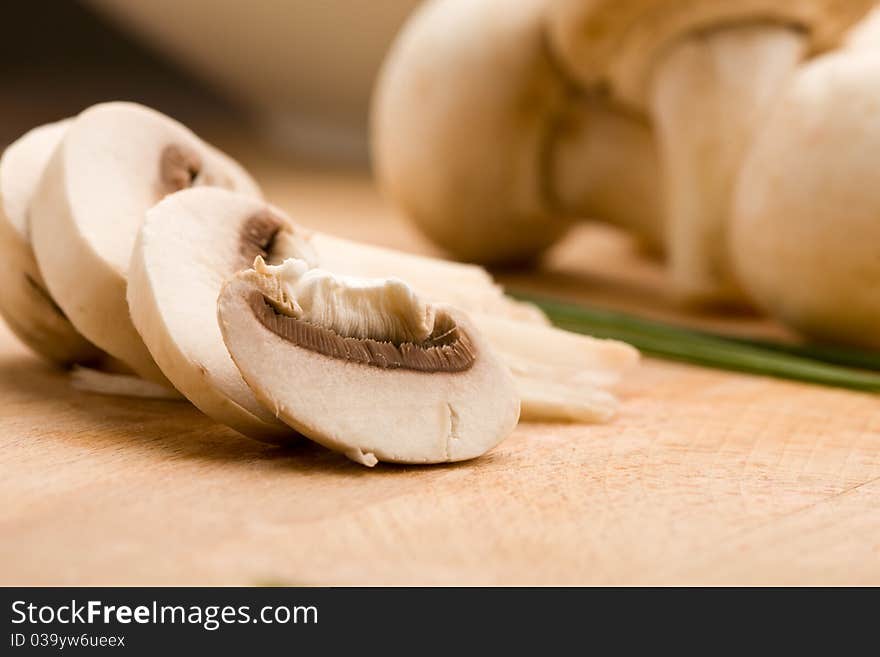 Photo of delicious raw mushroomw on chopping board. Photo of delicious raw mushroomw on chopping board