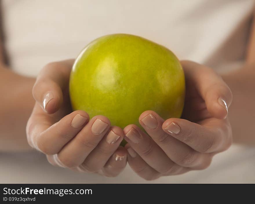 Fresh green apple in a woman hand close up