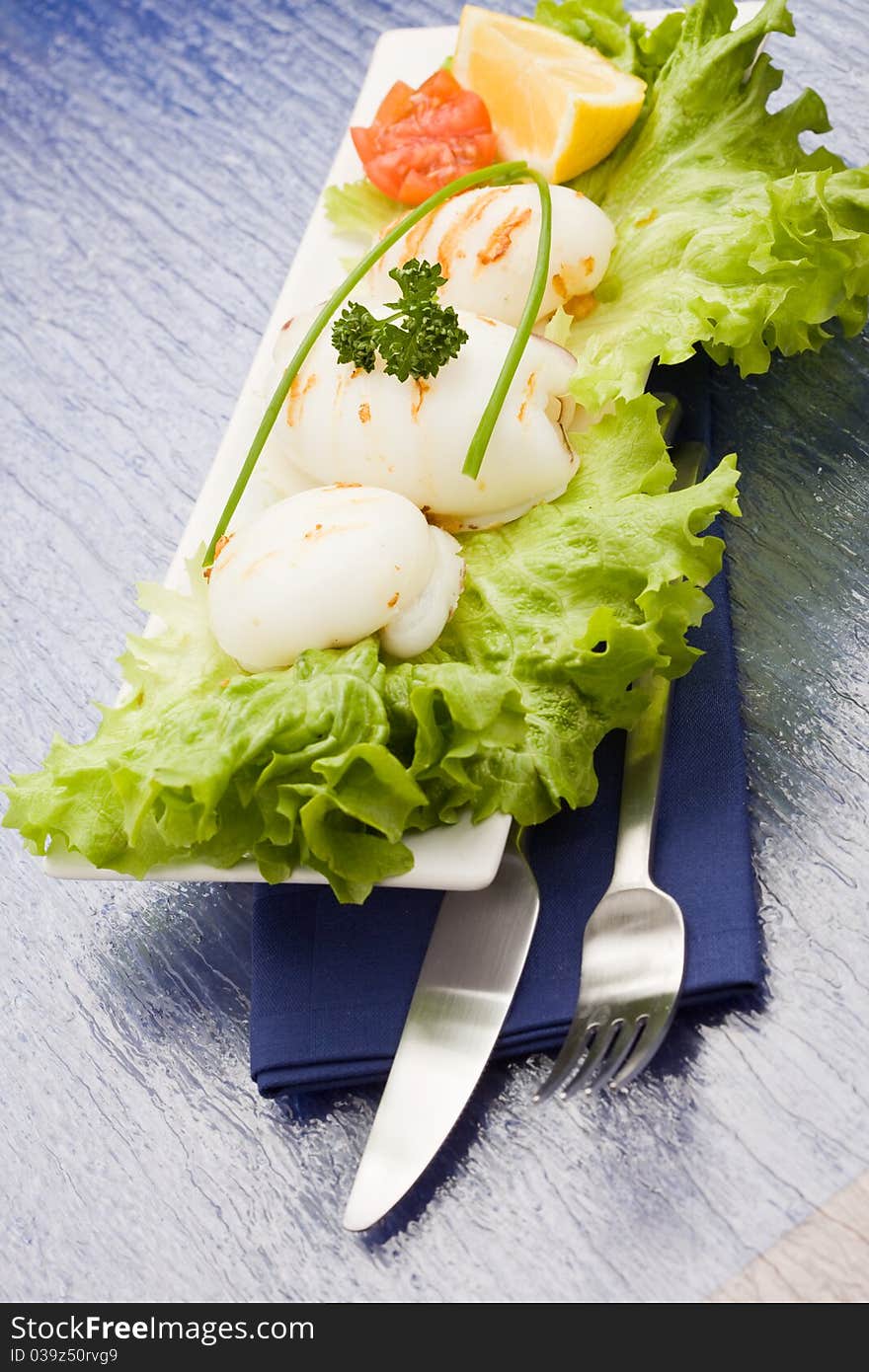 Squid With Lettuce On Blue Glasstable