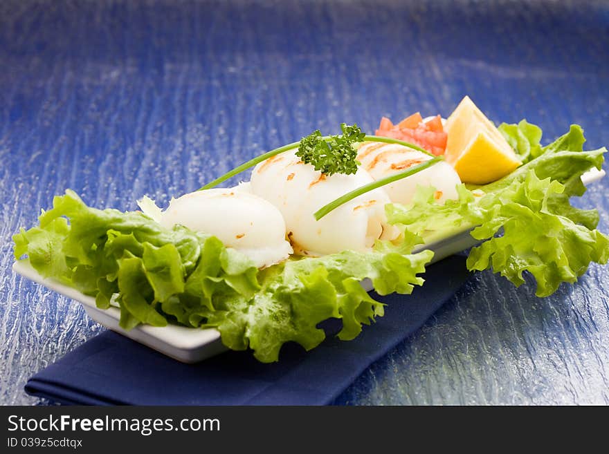 Squid With Lettuce On Blue Glasstable