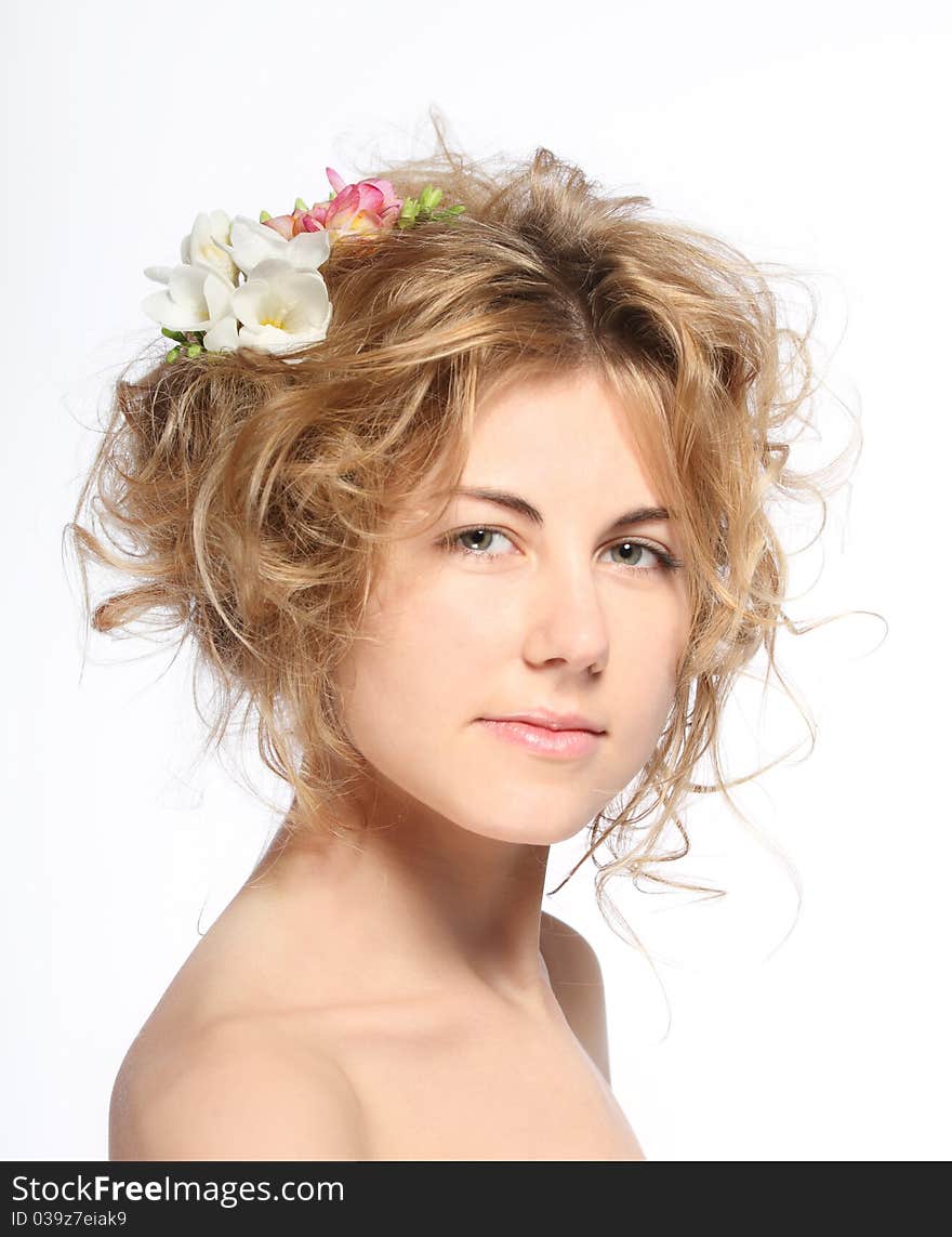 Portrait of the beauty young blond girl with freesia in her hair