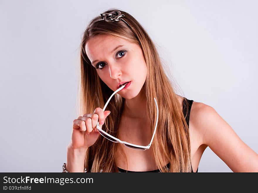 Attractive long-hair girl holding a white sunglasses. Attractive long-hair girl holding a white sunglasses