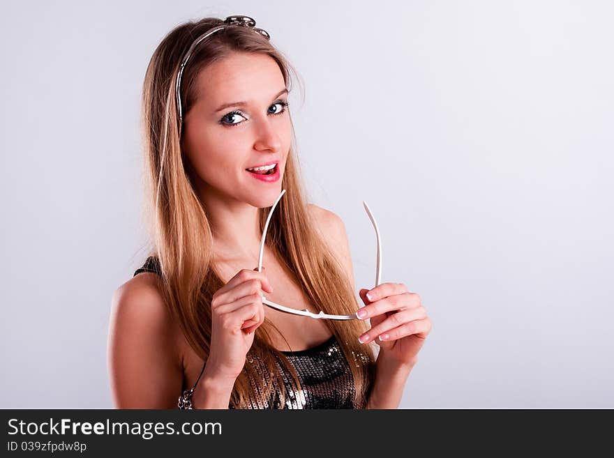 Attractive long-hair girl holding a white sunglasses. Attractive long-hair girl holding a white sunglasses