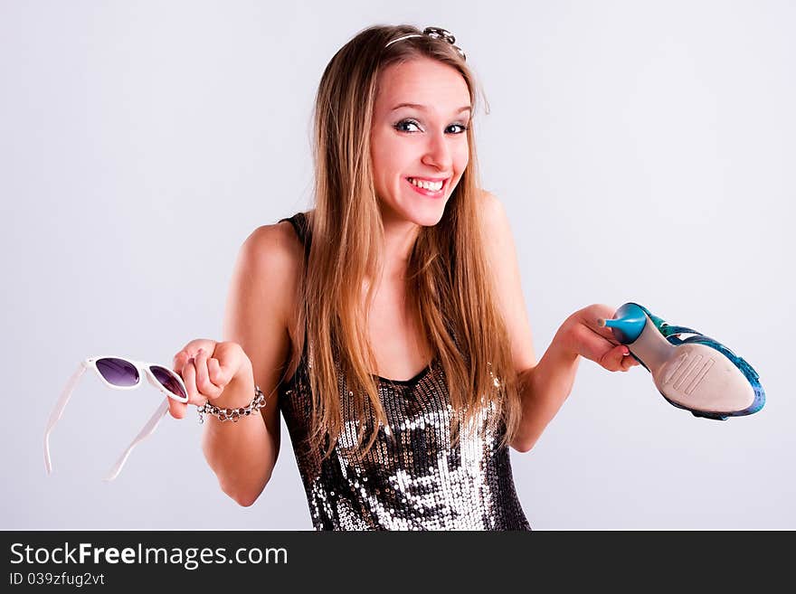 Pretty girl with shoe and sunglasses in hands