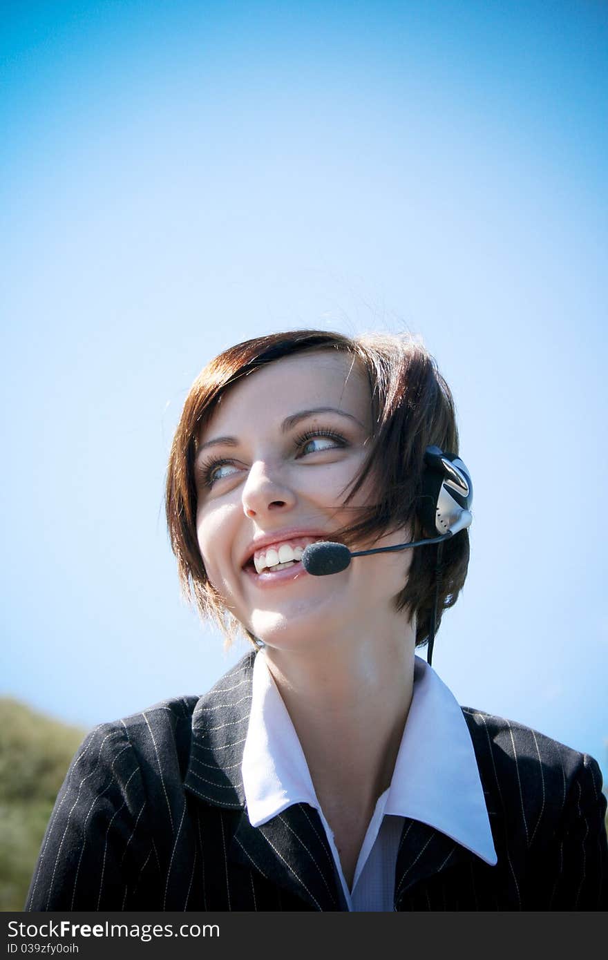 Young caucasian business lady with microphone and blue sky