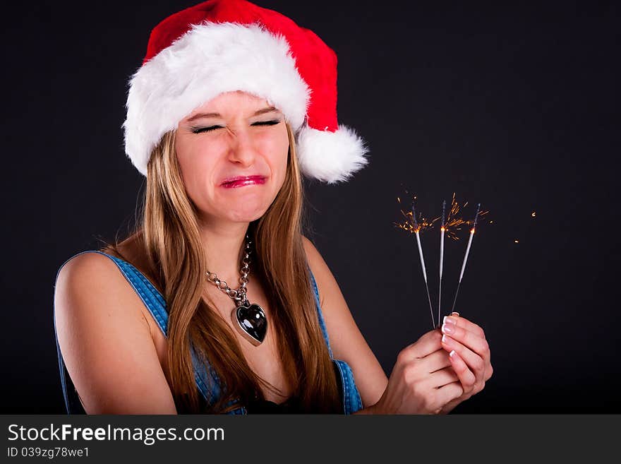 Cute girl in Santa hat holding sparklers. Cute girl in Santa hat holding sparklers