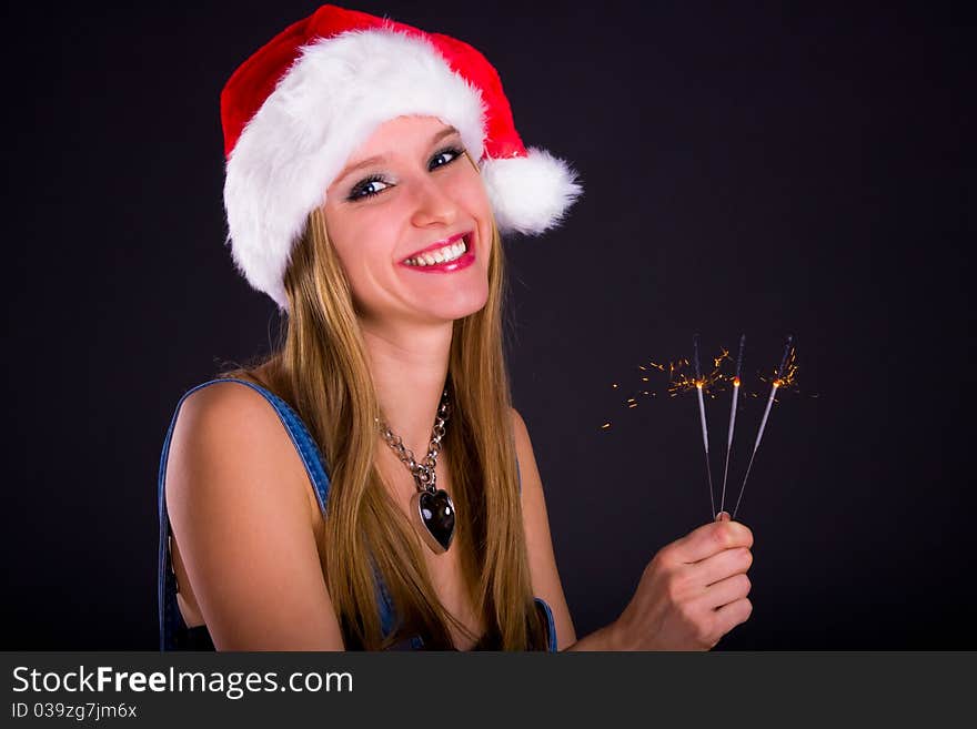 Cute girl in Santa hat holding sparklers. Cute girl in Santa hat holding sparklers