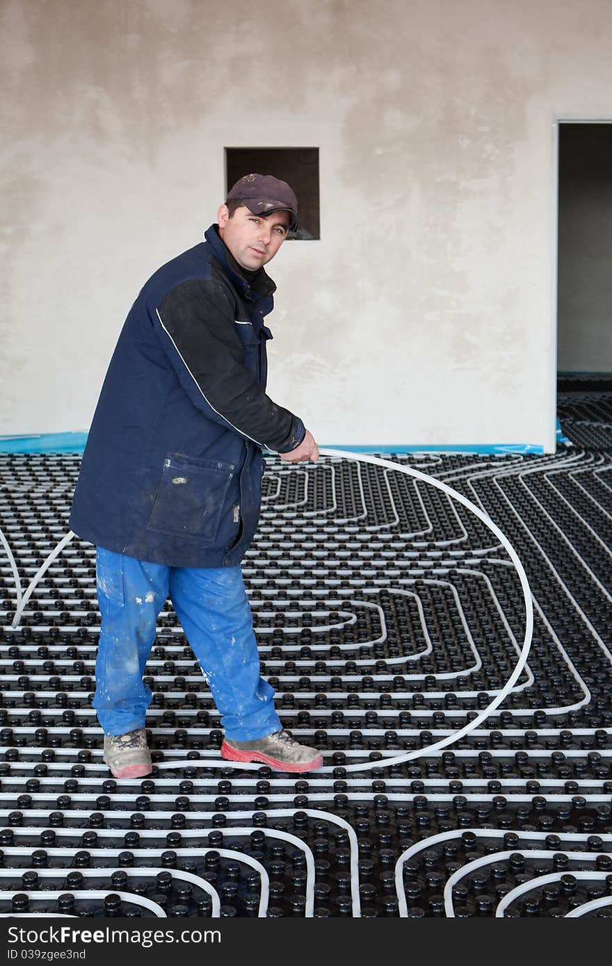 Underfloor heating and cooling, man work on building site