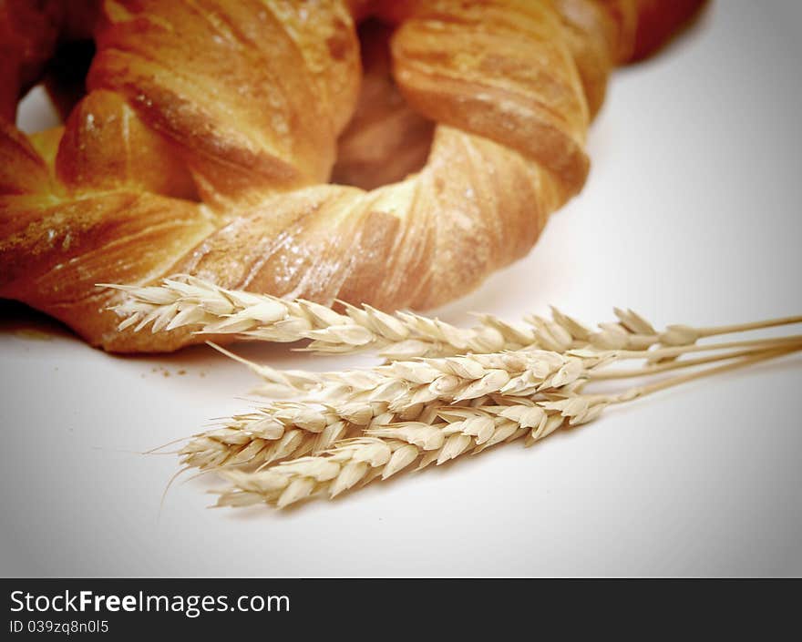 Bread with wheat ears on white background