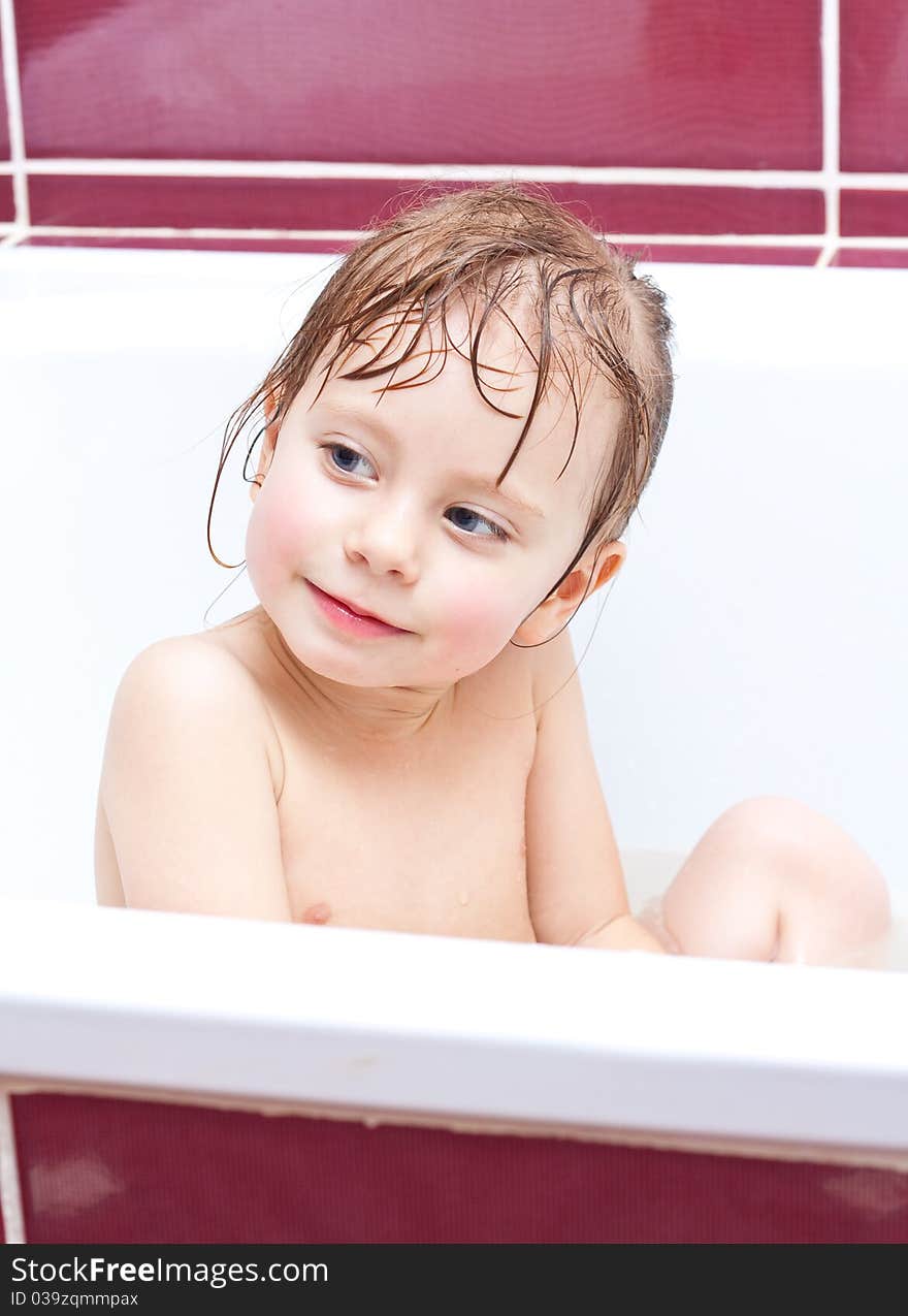 Girl looking out of a bath and smiling