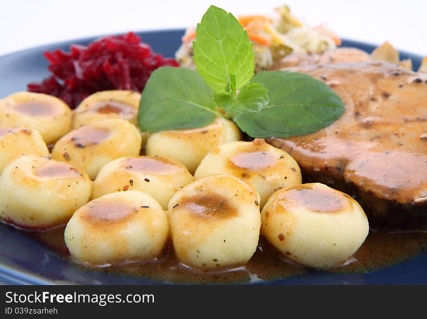 Pork steak and dumplings with side salads and baked onions