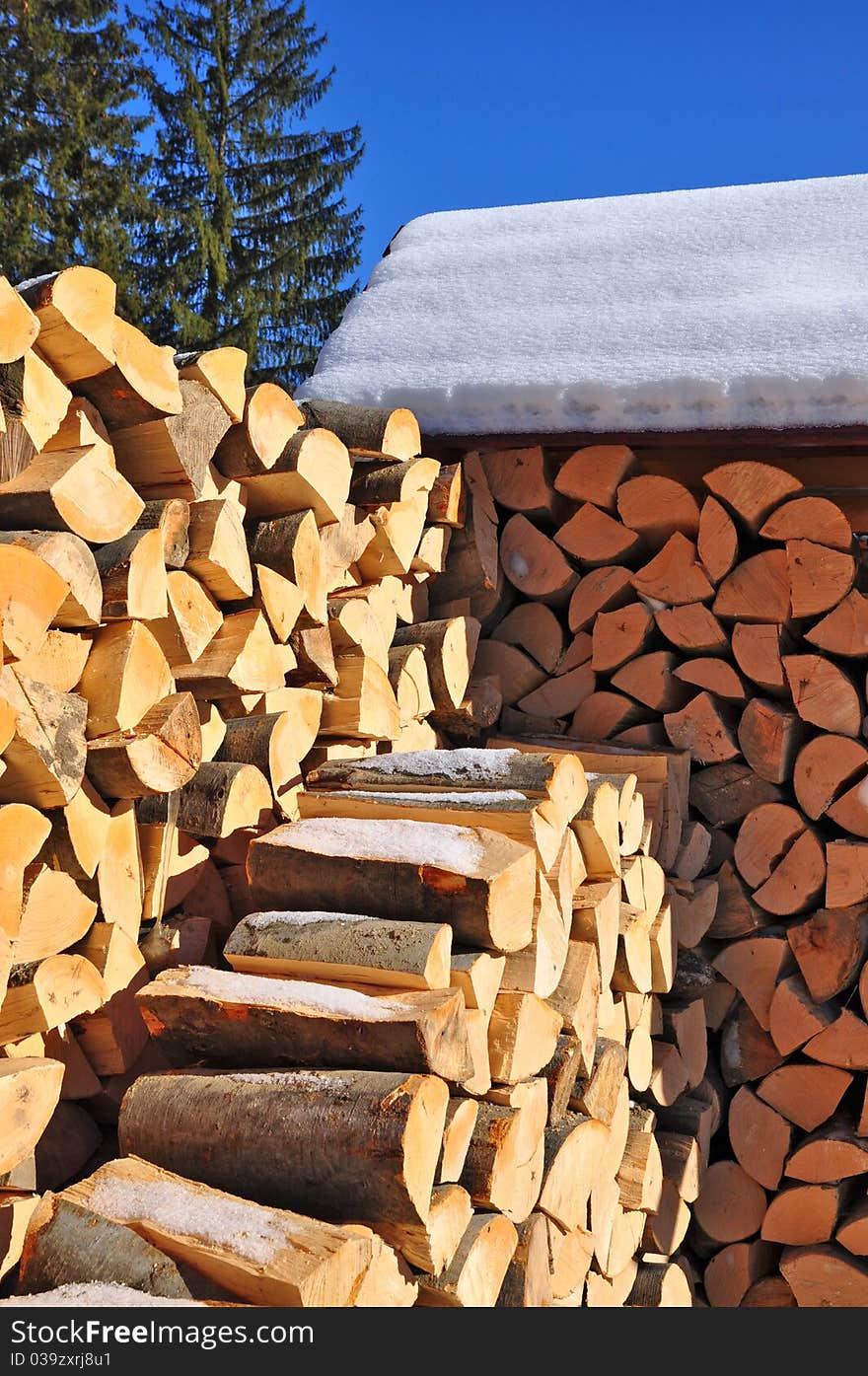 Fire wood under a canopy.