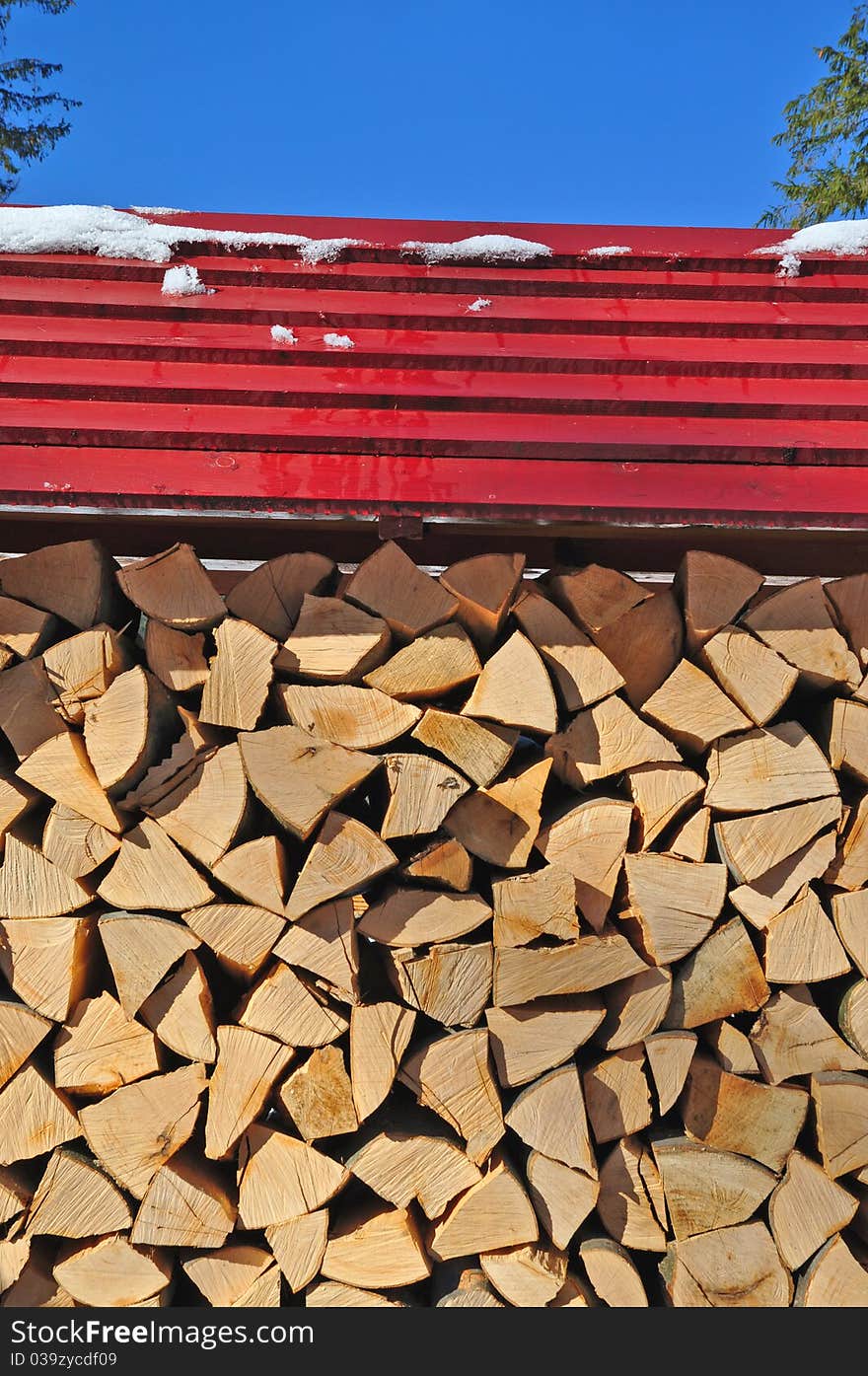 Fire wood under a canopy.