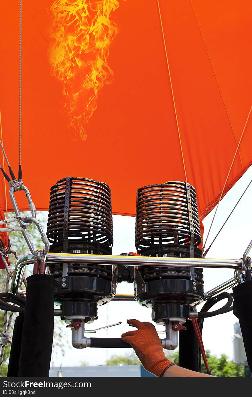 Man inflating an orange hot air balloon