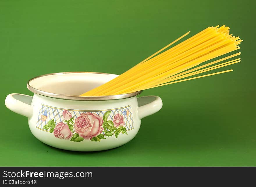 Pot with vermicelli green background close up