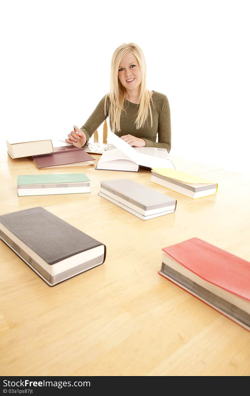 A woman is studying at a big table with a smile. A woman is studying at a big table with a smile.