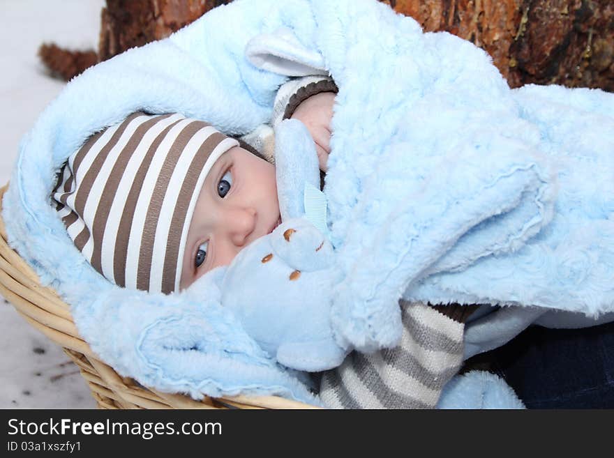 Cute baby boy lying outside in a basket. Cute baby boy lying outside in a basket