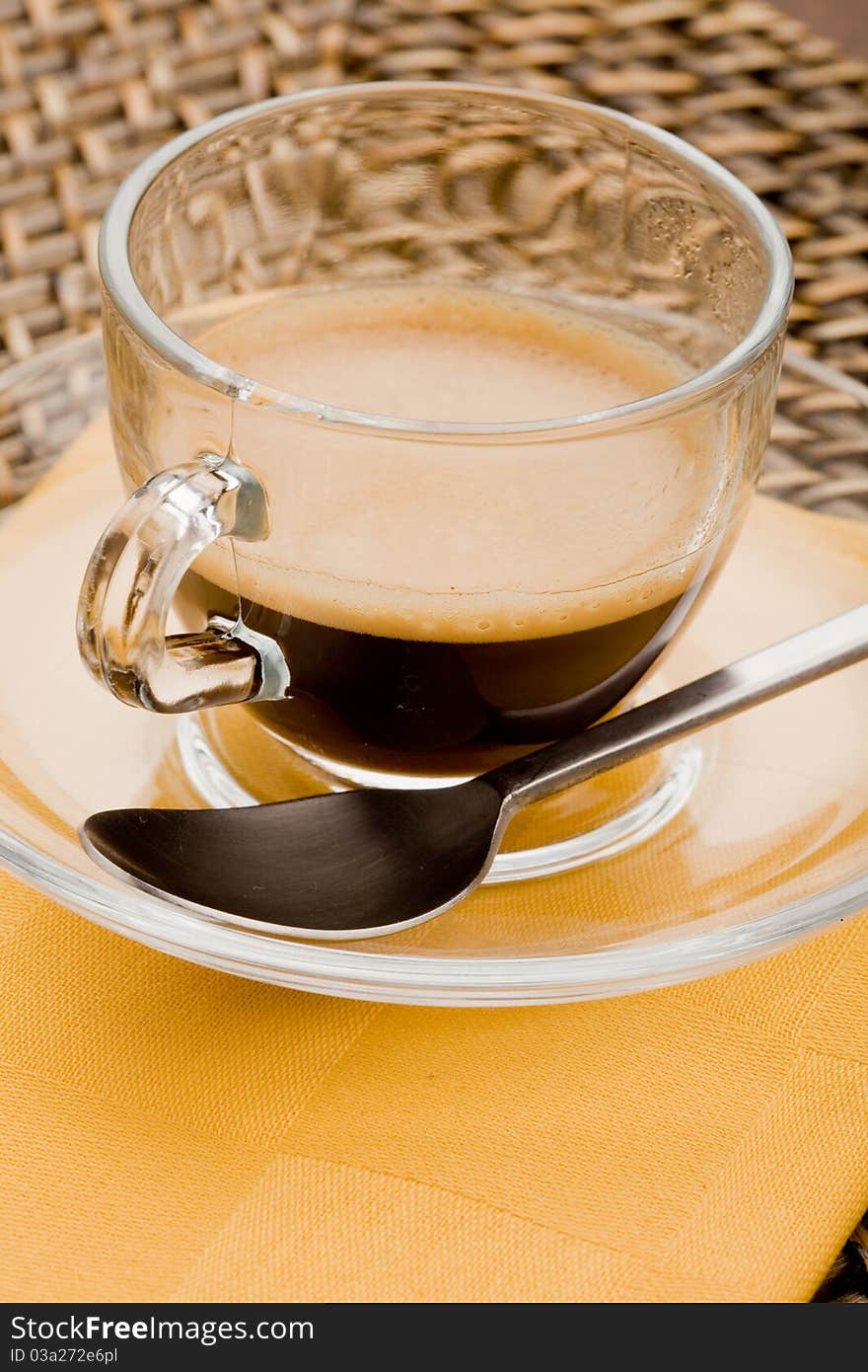 Photo of hot espresso coffee in glass cup with tea spoon