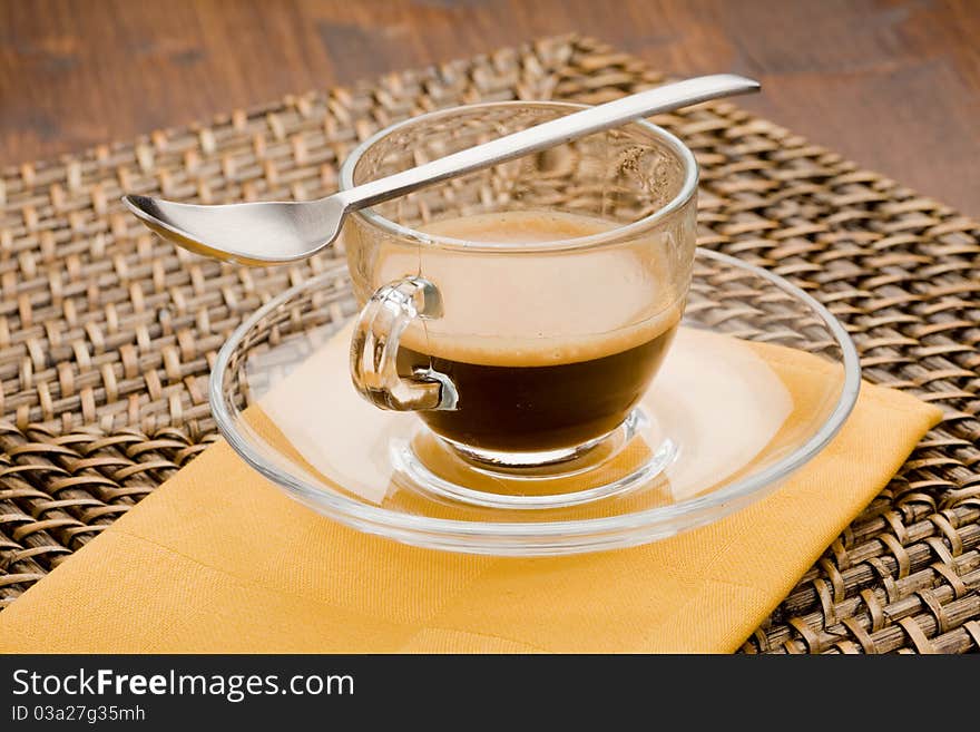 Photo of hot espresso coffee in glass cup with tea spoon