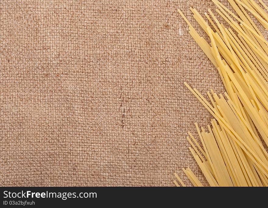 Raw spaghetti on the burlap background