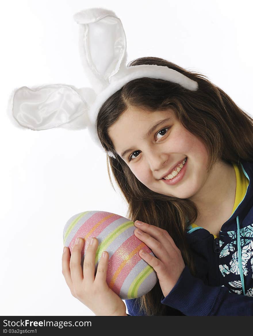 Closeup portrait of an attractive preteen girl in bunny ears while holding a bouquet of yellow flowers. Isolated on white. Closeup portrait of an attractive preteen girl in bunny ears while holding a bouquet of yellow flowers. Isolated on white.