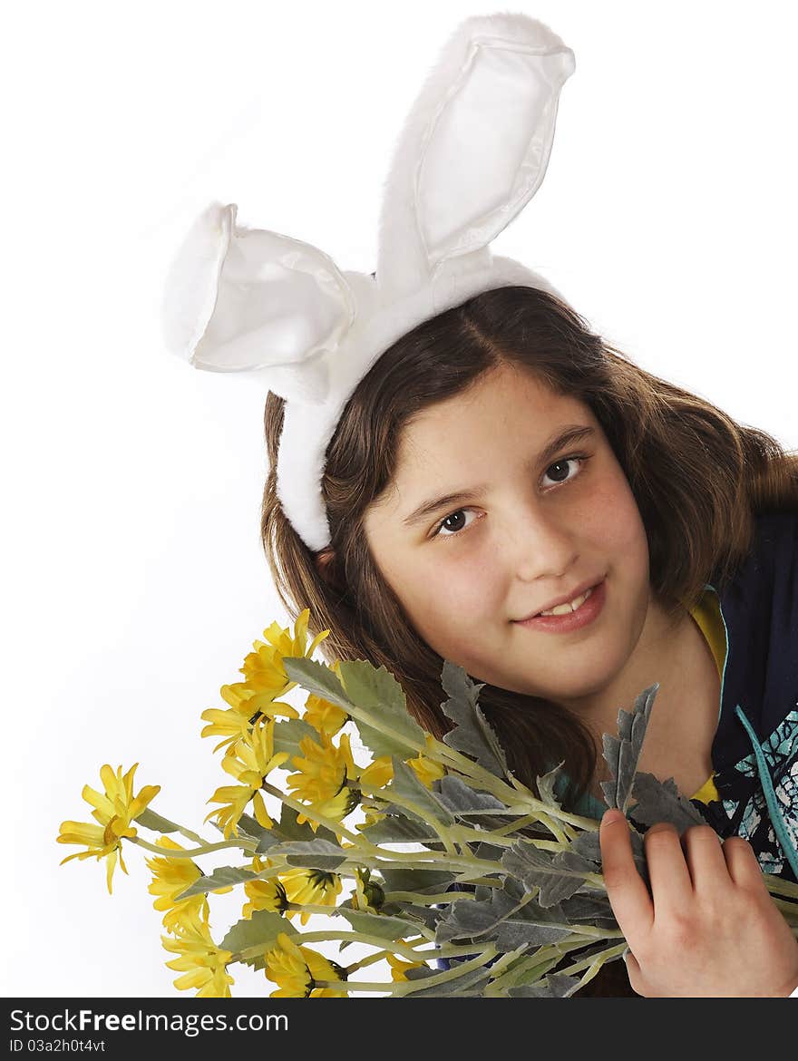 Closeup portrait of an attractive preteen girl in bunny ears while holding a bouquet of yellow flowers. Isolated on white. Closeup portrait of an attractive preteen girl in bunny ears while holding a bouquet of yellow flowers. Isolated on white.