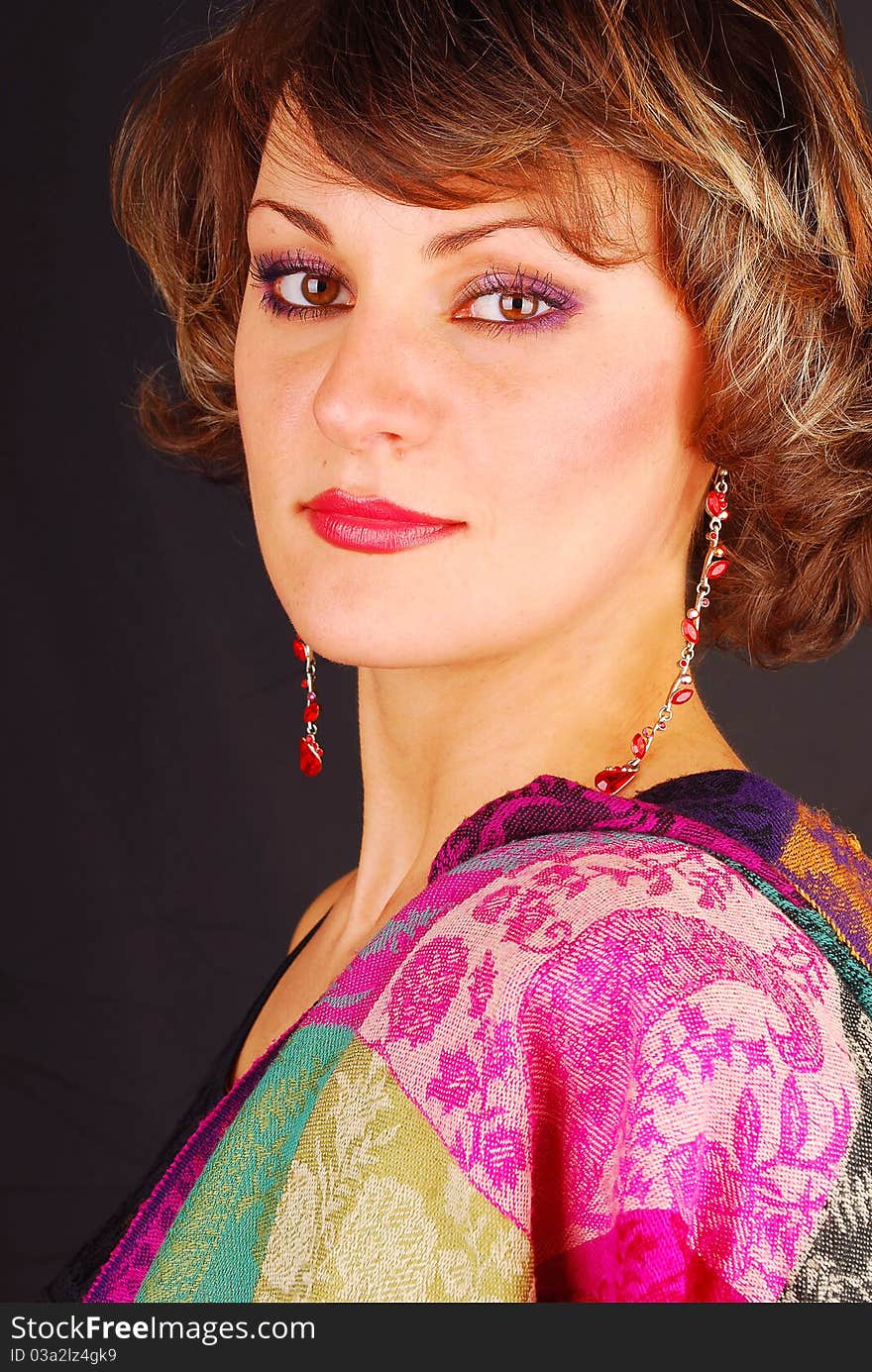 Young woman portrait with color scarf on the black background. Young woman portrait with color scarf on the black background.