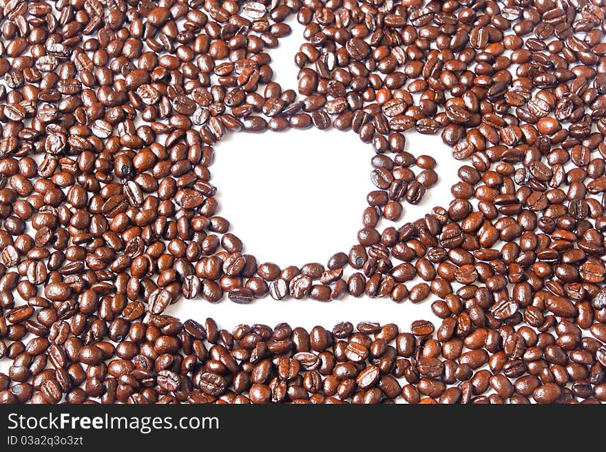 White coffee cup in many brown coffee beans for background